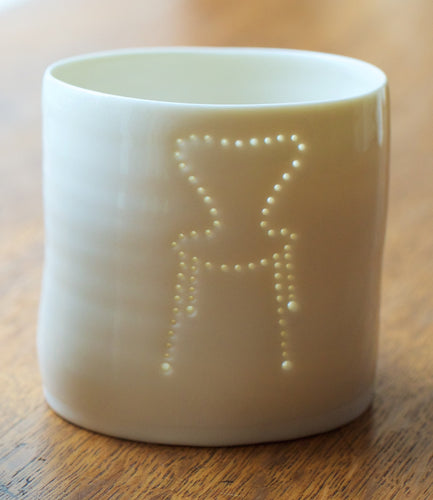 A porcelain tealight candle holder with a design of a midcentury classic chair