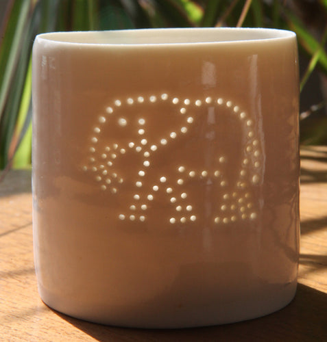 Tropical present. This porcelain ceramic tealight candle holder features a design of an elephant, pierced with tiny holes. Safari present.
