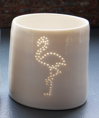 Tropical party present. This ceramic candle votive features a design of a flamingo. Holiday candle, this porcelain tealight holder glows from within once a candle is lit.