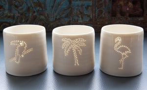 Paired with the palm tree and toucan, a tropical party present. This ceramic candle votive features a design of a flamingo. Holiday candle, this porcelain tealight holder glows from within once a candle is lit.